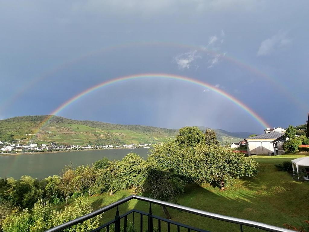 a rainbow in the sky over a body of water at Rainer´s Rheinblick in Oberdiebach