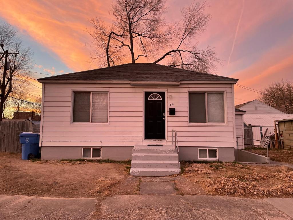 a pink house with a black door and a sunset at Cozy Home in the Heart of Pocatello in Pocatello