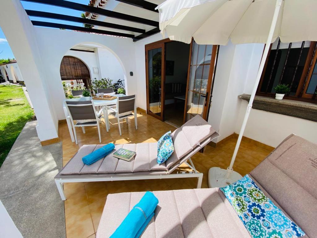 patio con divano, ombrellone e tavolo di Bungalow Parque Golf by SunHousesCanarias a Maspalomas