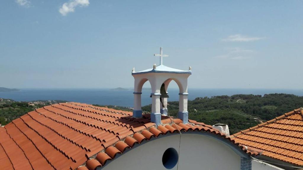 ein Kirchendach mit einem Kreuz darüber in der Unterkunft Traditional House Ekaterini Alonissos in Alonnisos Altstadt
