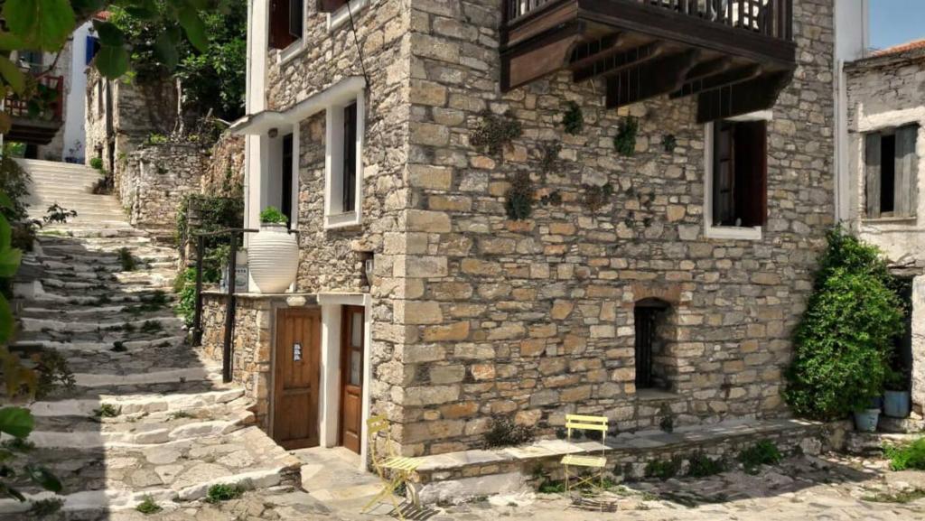 an old stone building with a staircase leading to a door at Traditional House Ekaterini Alonissos in Alonnisos