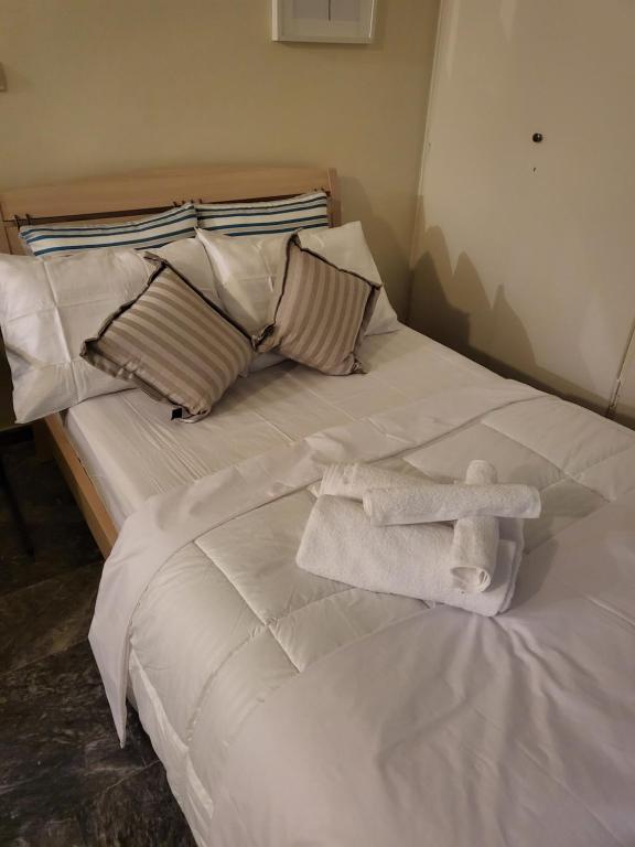uma cama branca com toalhas por cima em ATHENS HAUSE BY ATHENS em Atenas