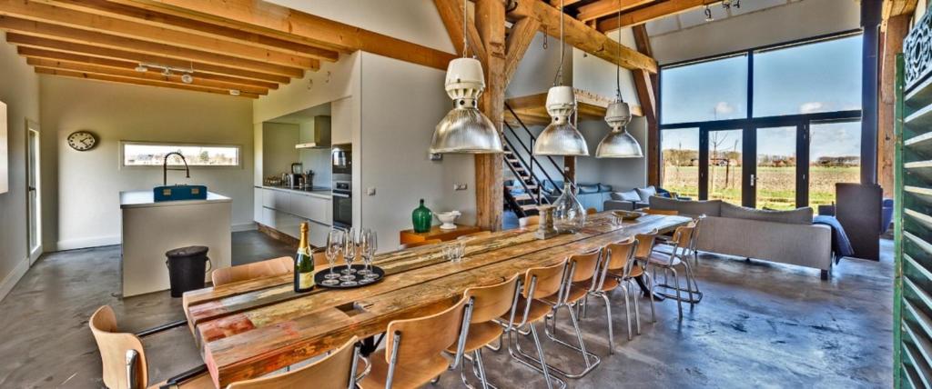 a kitchen and living room with a long table and chairs at TopLocatiezeeland # Sea Barn in Oostkapelle
