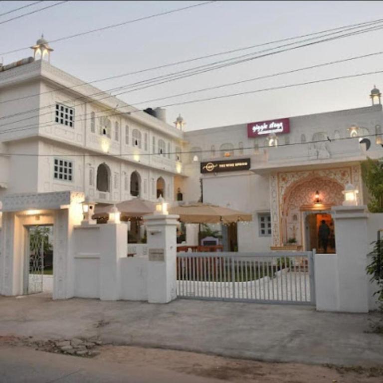 a large white building with a fence in front of it at Chirmi Palace - A Heritage Home in Jaipur