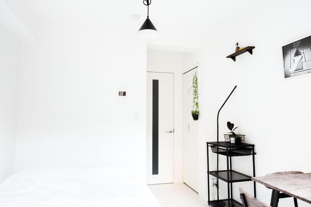 a dining room with white walls and a table at NEST HATAGAYA Stylish Apt in Tokyo