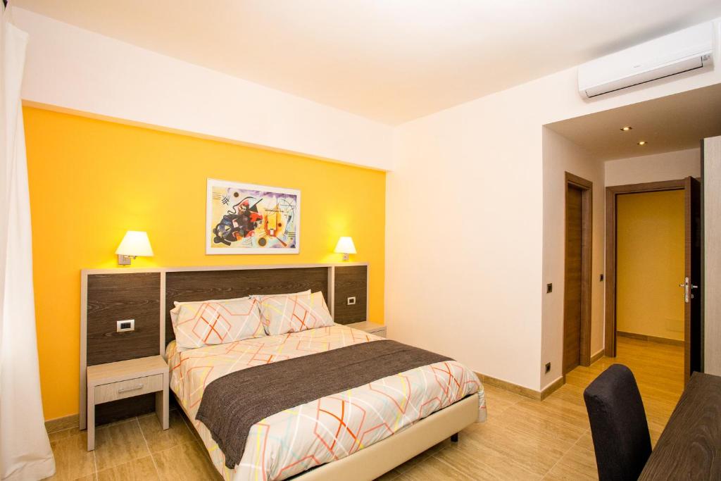 a bedroom with a bed and a yellow wall at Trastevere's Friends in Rome