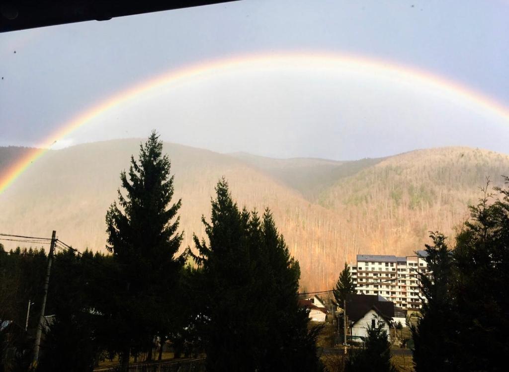 a rainbow in the sky over a mountain at The Nest in Sinaia