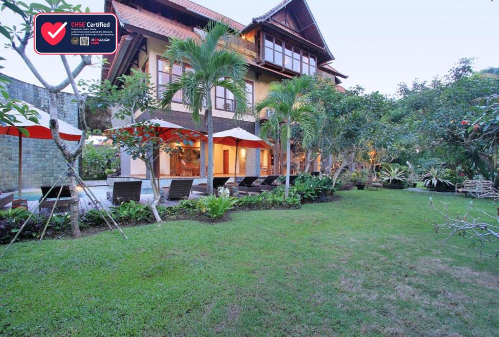 une maison avec une pelouse devant elle dans l'établissement Sarin Ubud Suites by Pramana Villas, à Ubud