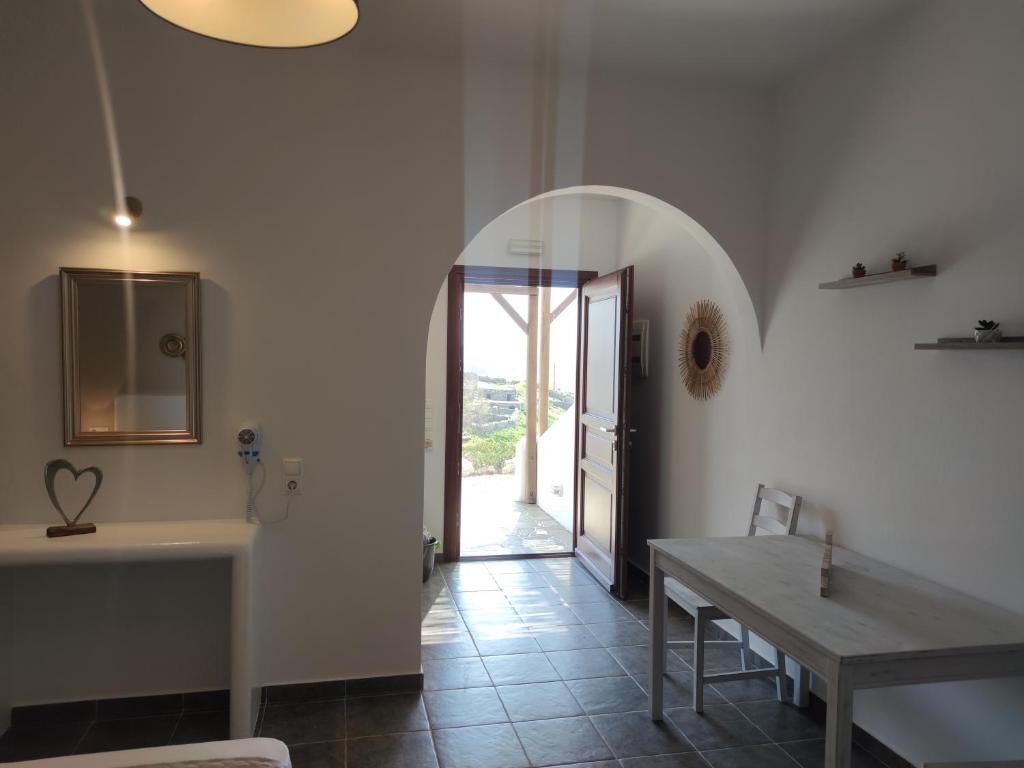 une salle à manger avec une table et un couloir avec une porte dans l'établissement Marianthi Studios, à Áno Meriá