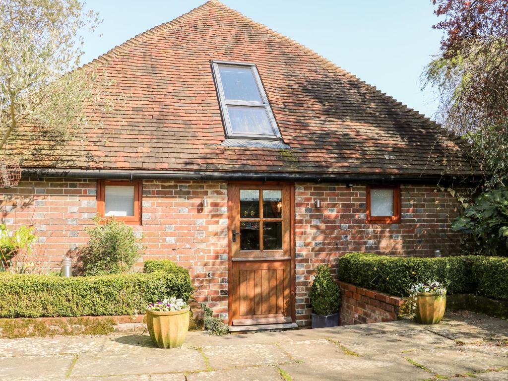 een rood bakstenen huis met een houten deur bij The Old Granary in Pulborough