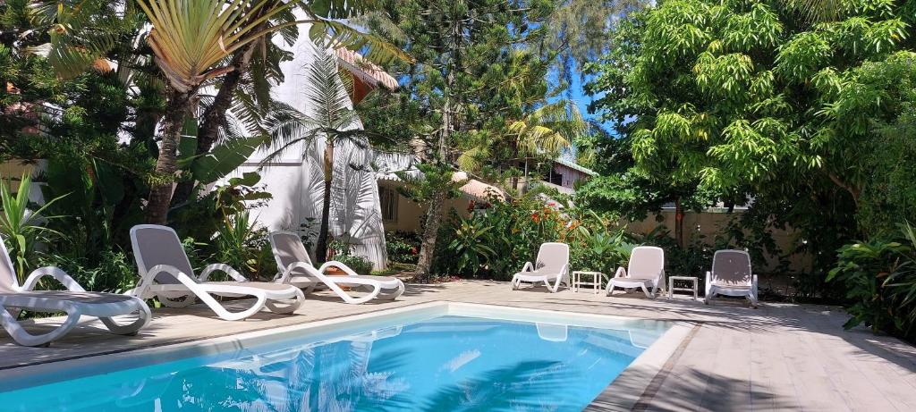 a group of chairs and a swimming pool with a bunch at Lush Garden Villa with private pool in Trou aux Biches