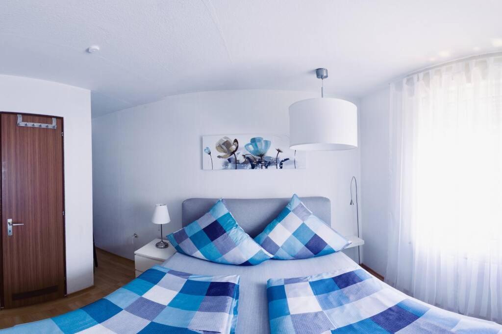 a bedroom with a bed with blue and white pillows at Gemütliche Wohnung im Schwarzwald in bester Lage von Bad Wildbad in Bad Wildbad