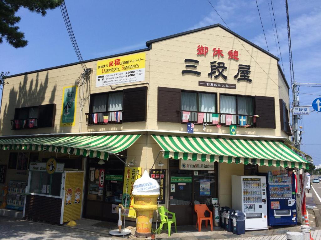 a building with a fire hydrant in front of it at Dormitory Sandanya Guesthouse in Shirahama