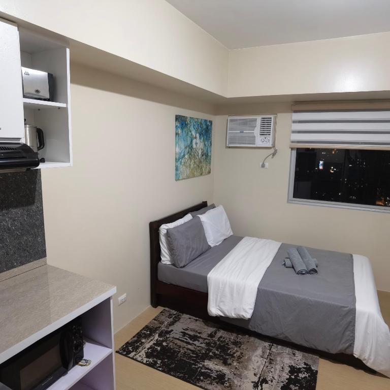 a small bedroom with a bed and a window at Avida Davao Condos, downtown CM Recto Avenue, Davao City in Davao City