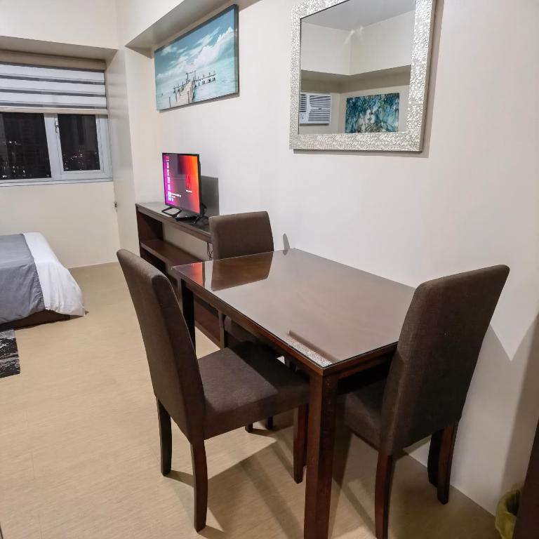 a dining room table with chairs and a computer on a desk at Avida Davao Condos, downtown CM Recto Avenue, Davao City in Davao City