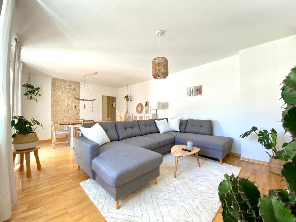un soggiorno con divano blu e tavolo di Best Butler Boho Boutique City Apartment Netflix a Füssen