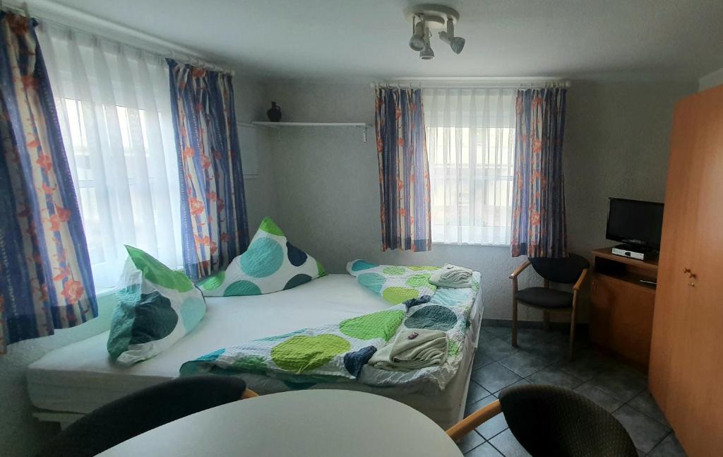 um pequeno quarto com uma cama e 2 janelas em Miniferienhaus Bad Elster em Bad Elster