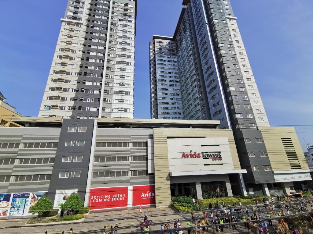 two tall buildings in a city with people standing in front at Avida Davao Condos, downtown CM Recto Avenue, Davao City in Davao City