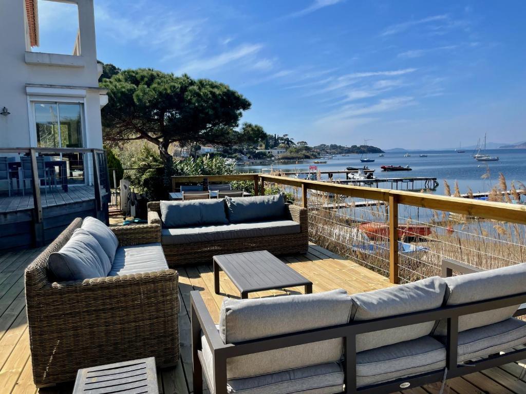balcón con sofás y vistas al agua en Villa Bord de Mer Accès Plage Presqu'île de Giens-Sea and Mountain Pleasure, en Hyères