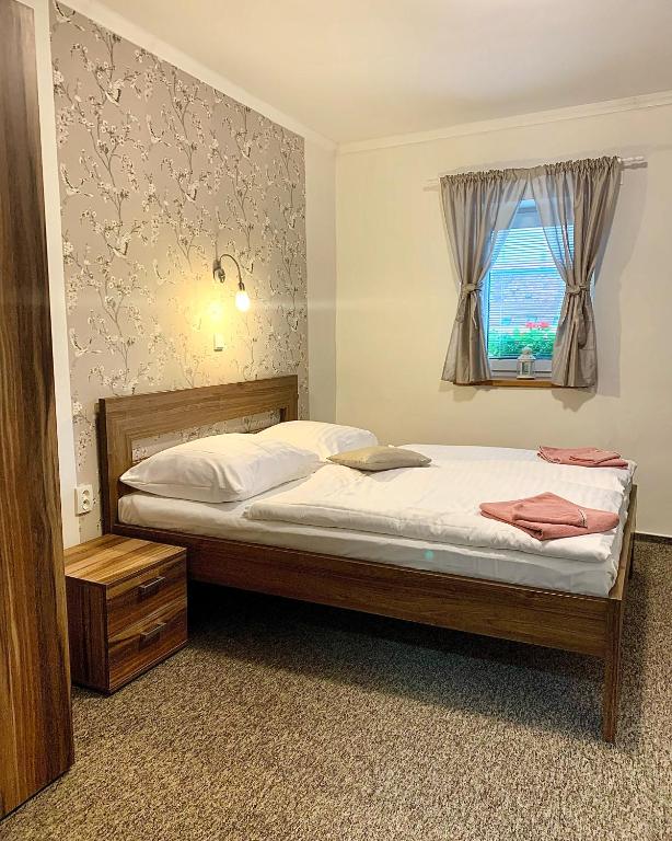 a bedroom with a bed and a window at Ubytování Selský Dvůr in Valtice