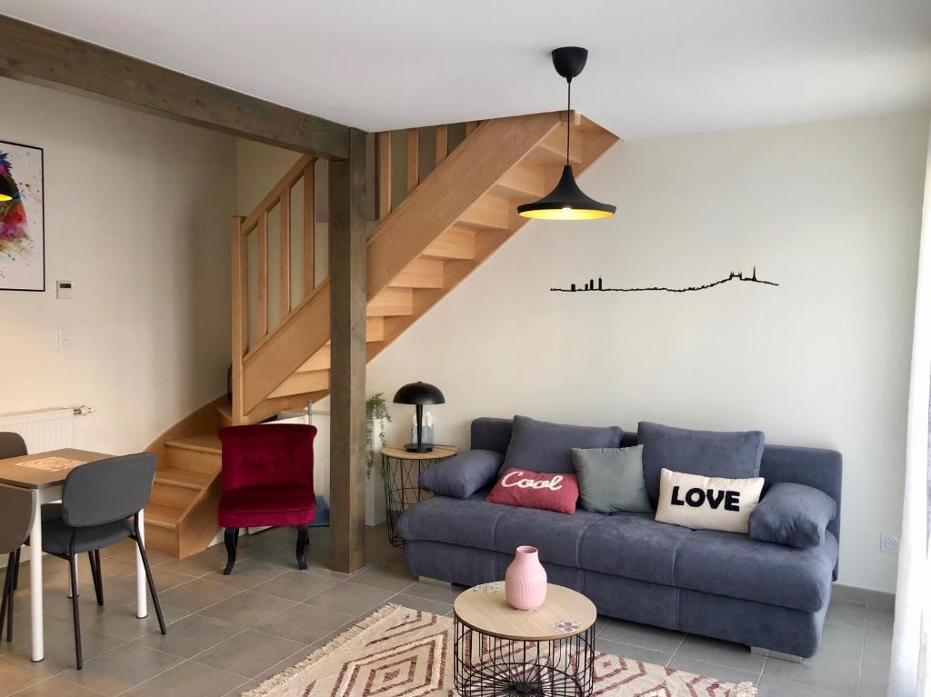 salon z niebieską kanapą i schodami w obiekcie T2 en duplex & terrasse w mieście Saint-Priest