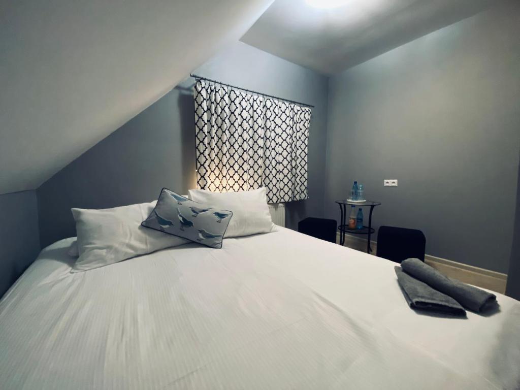 1 dormitorio con 1 cama con sábanas blancas y ventana en Pokoje Gościnne u Kovi, en Legnica