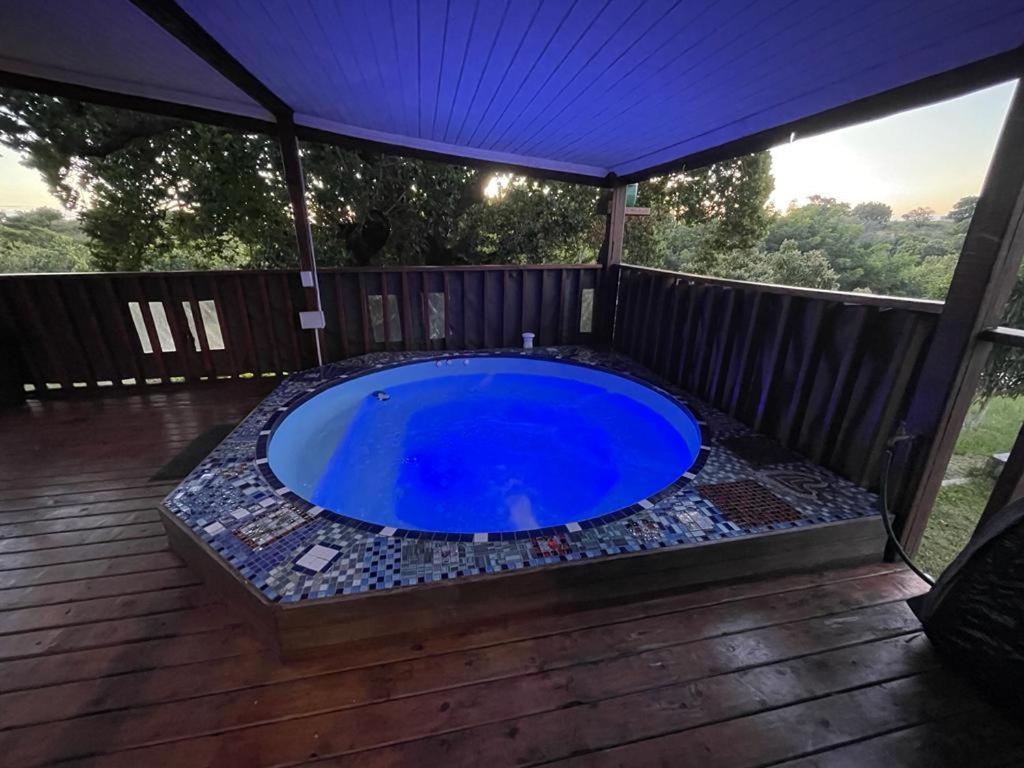 a large blue pool on a deck with a canopy at Kosy place in KwaMazambane