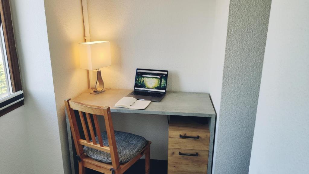 a desk with a computer on it with a chair at Kleines aber feines Apartment in Gelsenkirchen
