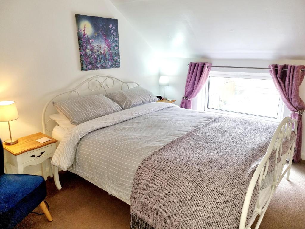 a bedroom with a large white bed and a window at Ladybird Cottage, Dog Friendly, Couples or Small families, Yorkshire Wolds - Countryside and Coast in Great Driffield