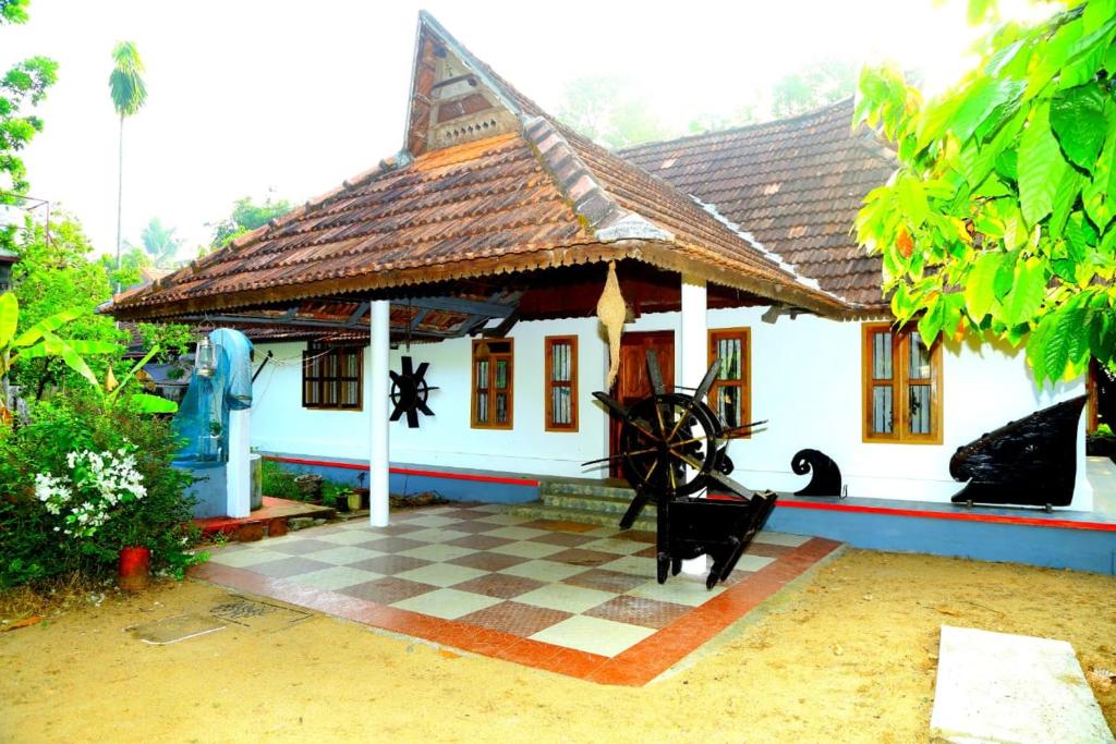 a house with a checkered floor in front of it at VALENTINE'S RICE BOWL HOME STAY in Alleppey