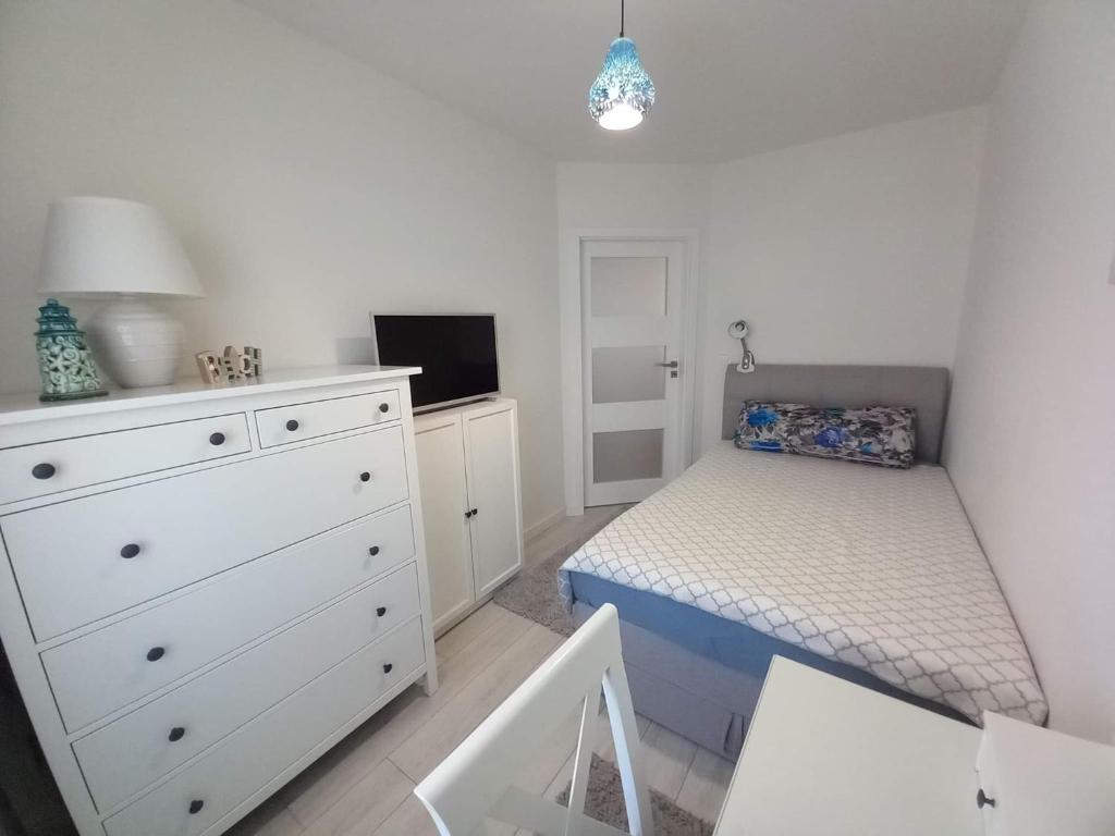 a bedroom with a bed and a dresser and a bed and a dresser at Apartament Jantar Park in Jantar