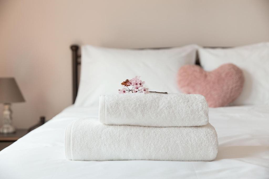 three towels stacked on top of a white bed at Sirens Athens Apartment in Athens