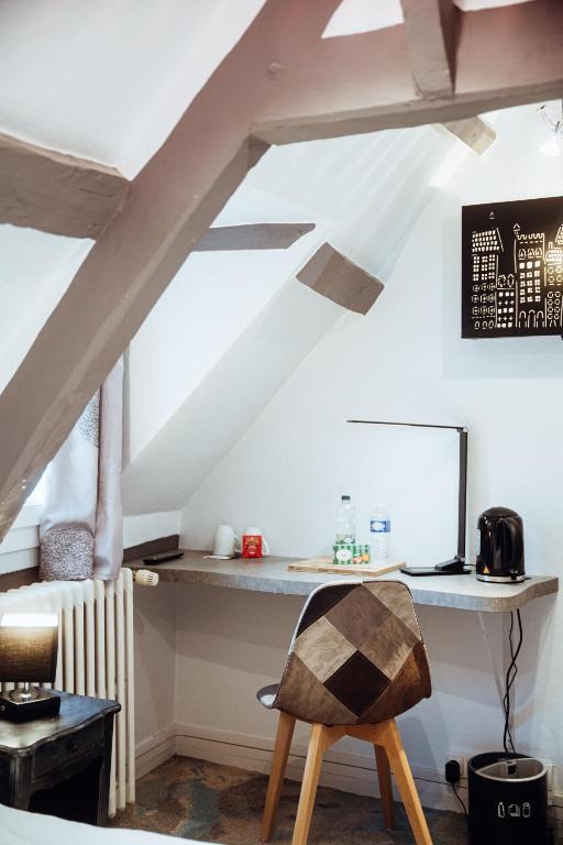 a room with a desk in the attic at Hotel Le Dauphin in Honfleur