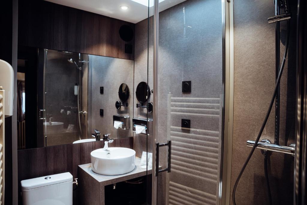 a bathroom with a sink and a shower at Hotel Le Dauphin in Honfleur