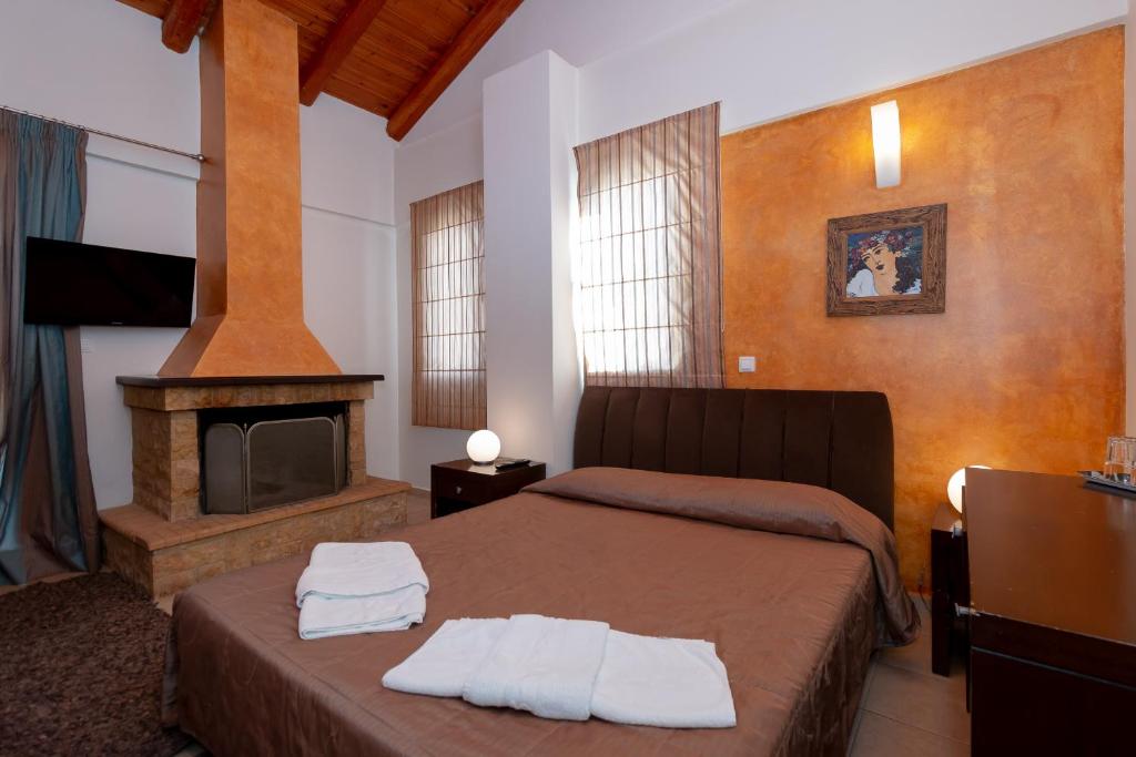 ein Schlafzimmer mit einem Bett und einem Kamin in der Unterkunft Ahilion Hotel in Kalavryta