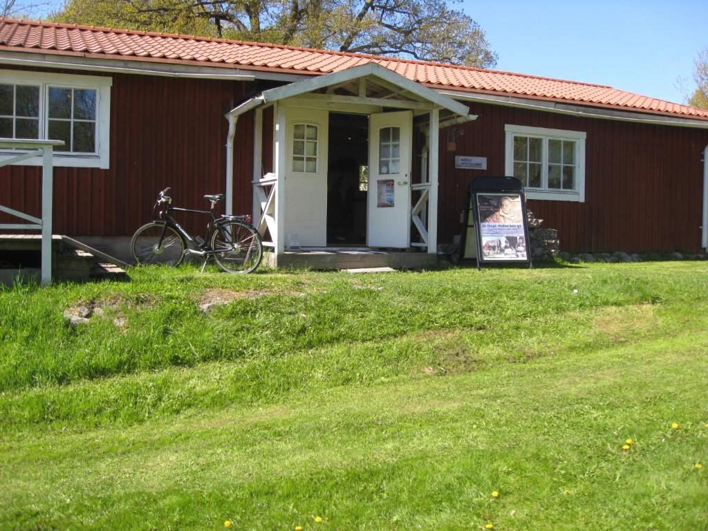 a red house with a bike parked in front of it at Galleri huset studio in Blankaholm