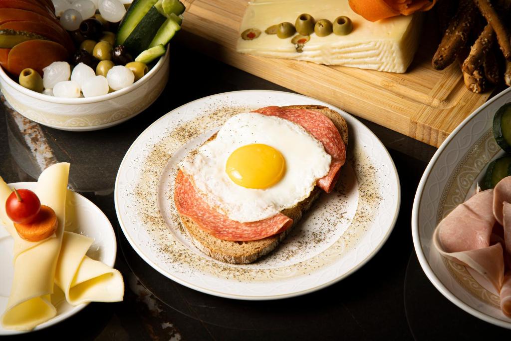 a sandwich with an egg on a plate on a table at Hotel Villa Romeo in Catania