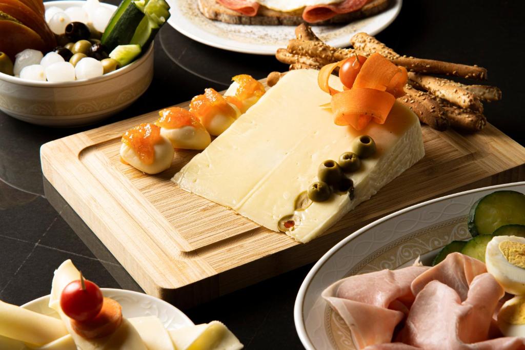 a table topped with plates of cheese and other foods at Hotel Villa Romeo in Catania
