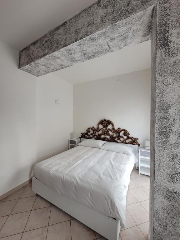 una camera con un grande letto bianco di Casa BuIIo a Chioggia