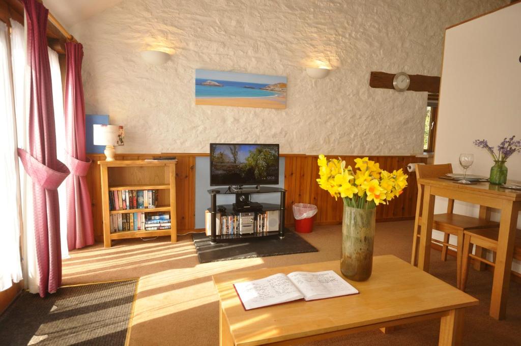 uma sala de estar com uma mesa e uma televisão em Bowgie at Trewerry Cottages - Away from it all, close to everywhere em Newquay