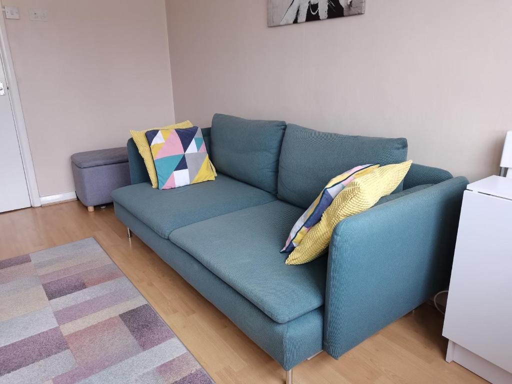 a blue couch with pillows on it in a living room at Charming London Town Studio Flat, Tower Bridge in London
