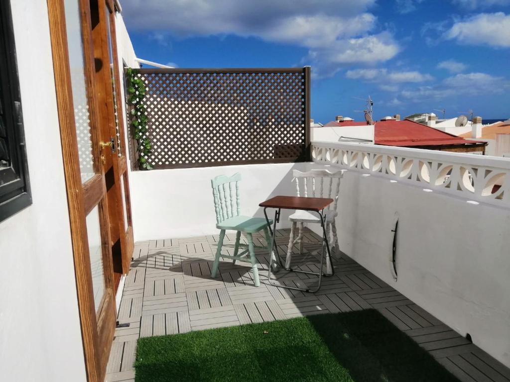 a patio with two chairs and a table on a balcony at Morro Mar in Morro del Jable