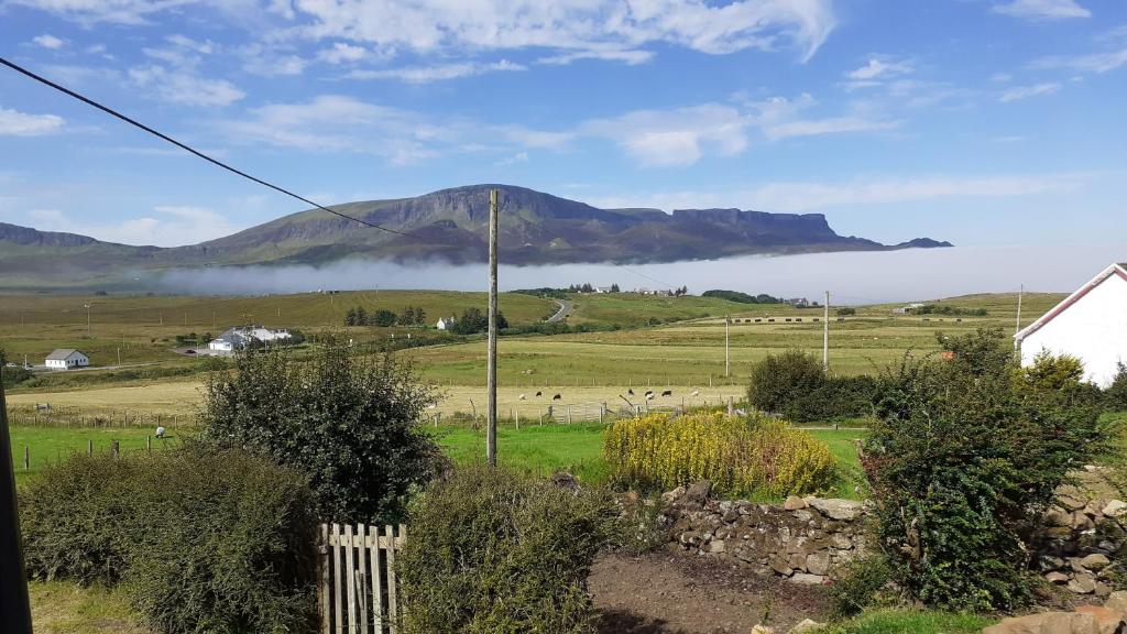 a view of a mountain in a field with a fence at Tigh Quiraing- Heather in Staffin