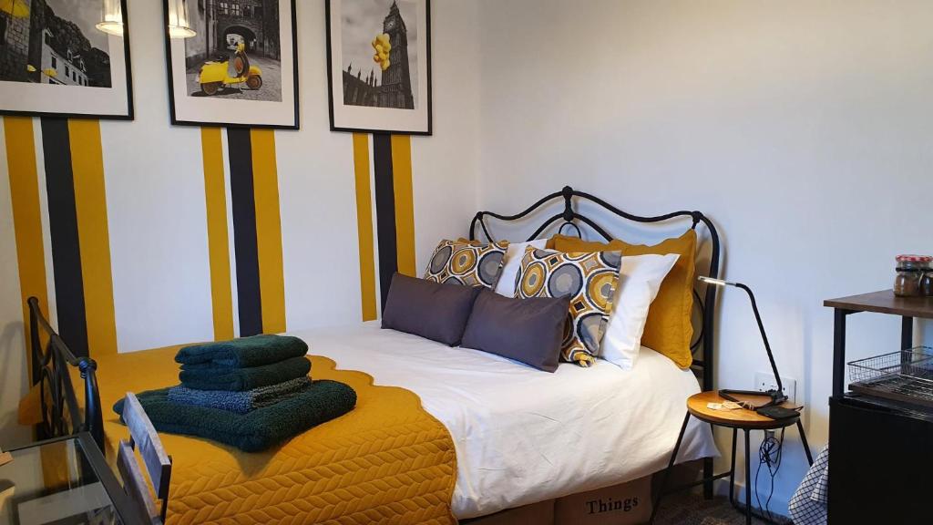 ein Schlafzimmer mit einem Bett in einem Zimmer mit Bildern an der Wand in der Unterkunft Kew Gardens - Private Double Room Richmond London - Homestay in Kew Gardens