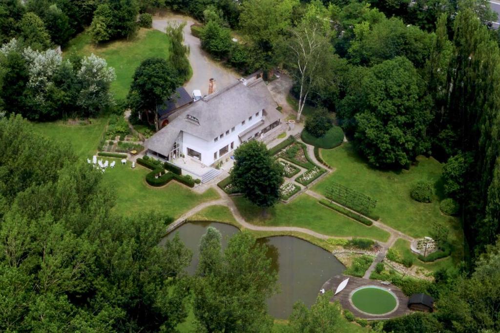 an aerial view of a large house with a river at Raesborre in Leuven