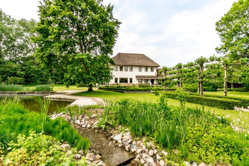 een tuin met een huis en een vijver bij Raesborre in Leuven