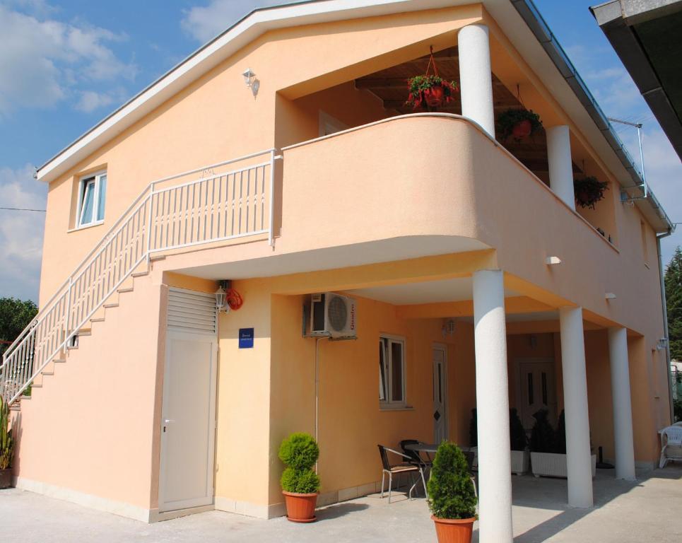 
a white and blue house with a balcony at Apartments Kairos - Bili 9 in Kaštela
