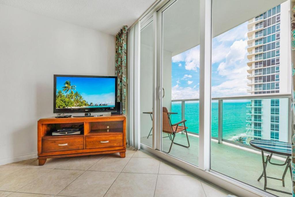 sala de estar con TV y balcón con vistas al océano en Tides Beachfront Apartments, en Hollywood