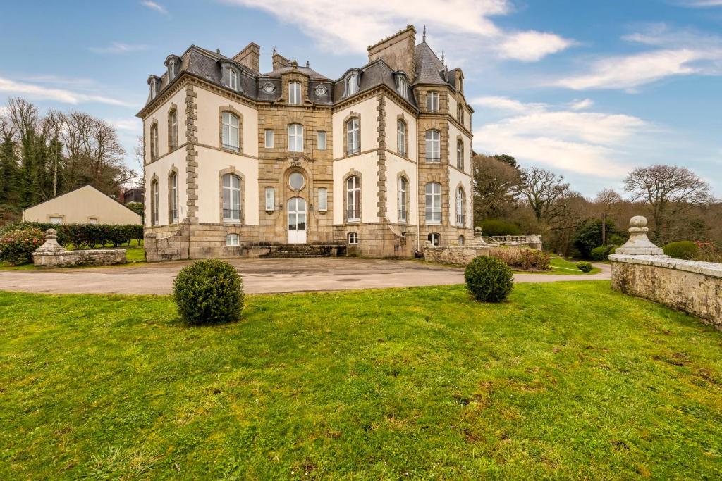 an old house with a grass yard in front of it at château de Locquéran Pierres et filets bleus in Plouhinec