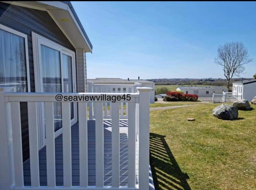 a white fence on a house with a yard at Seaview Homes in Hastings
